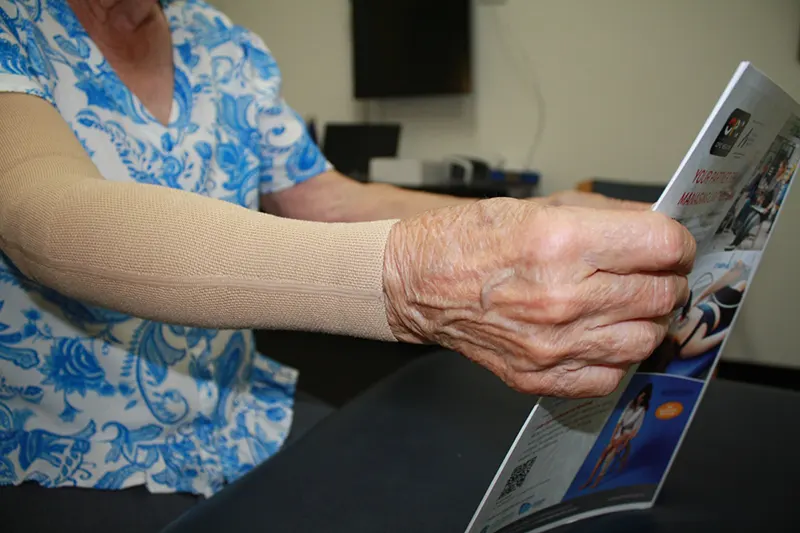 Elderly patient wearing compression sleeve on upper limb after lymphoedema treatment at Perth Lymphoedema Clinic